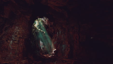 exploring a dark and mysterious cave: sunlight rays illuminate the path