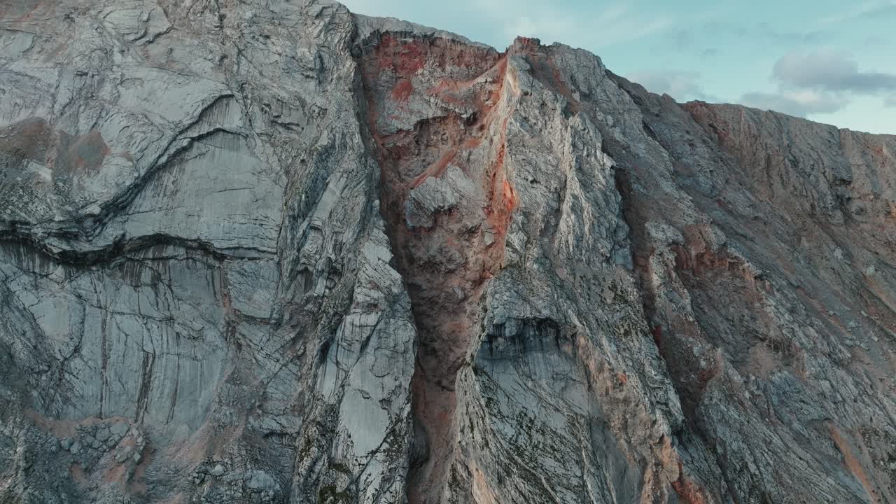 Stunning mountain wall close-up in Peder&uuml;, South Tyrol, showcasing unique rock formations under a blue sky