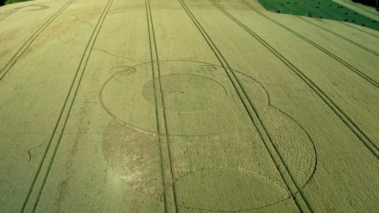 Wiltshire Wootton rivers mysterious crop circle in countryside farmland field aerial view pull back reveal