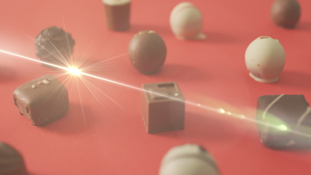 animación de la luz sobre pralinas de chocolate en superficie roja