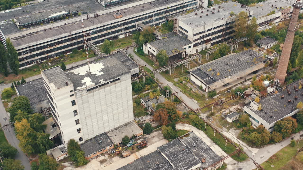 Old factory background. Exterior of industrial buildings of abandoned plant. Empty large area with with old warehouses and tall building. Aerial view.