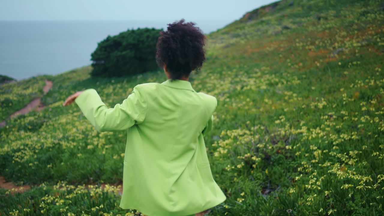 Woman performing playful dance on flowers meadow closeup. Girl dancing freestyle