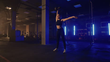 entrenamiento de potencia en el gimnasio mujer está levantando pesas en la sala de fitness entrenamiento solo por la noche