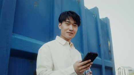 young man with smartphone and drink