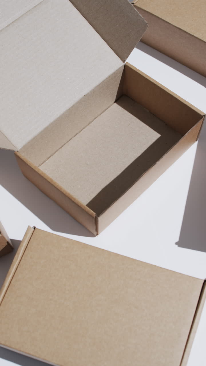 Vertical video of cardboard boxes with copy space over white background