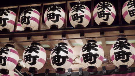 close-up of traditional japanese paper lanterns with symbols on it