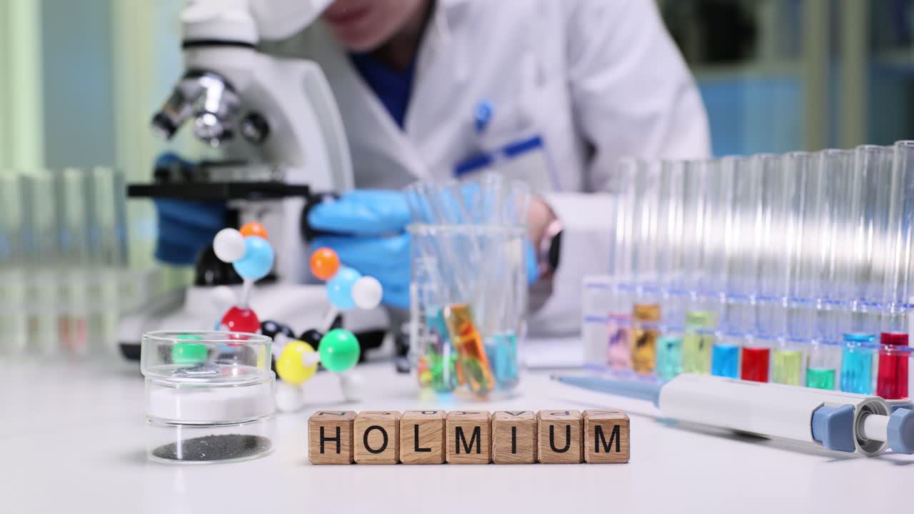 Các khối nguyên tố Holmium trên bàn thí nghiệm cùng nhà khoa học và thiết bị.