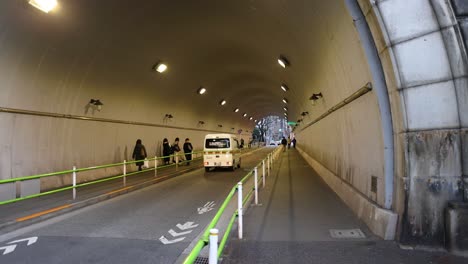 ambulance driving through tunnel with pedestrians