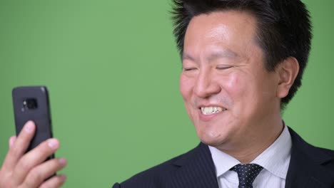 녹색 배경에 성숙한 일본 사업가