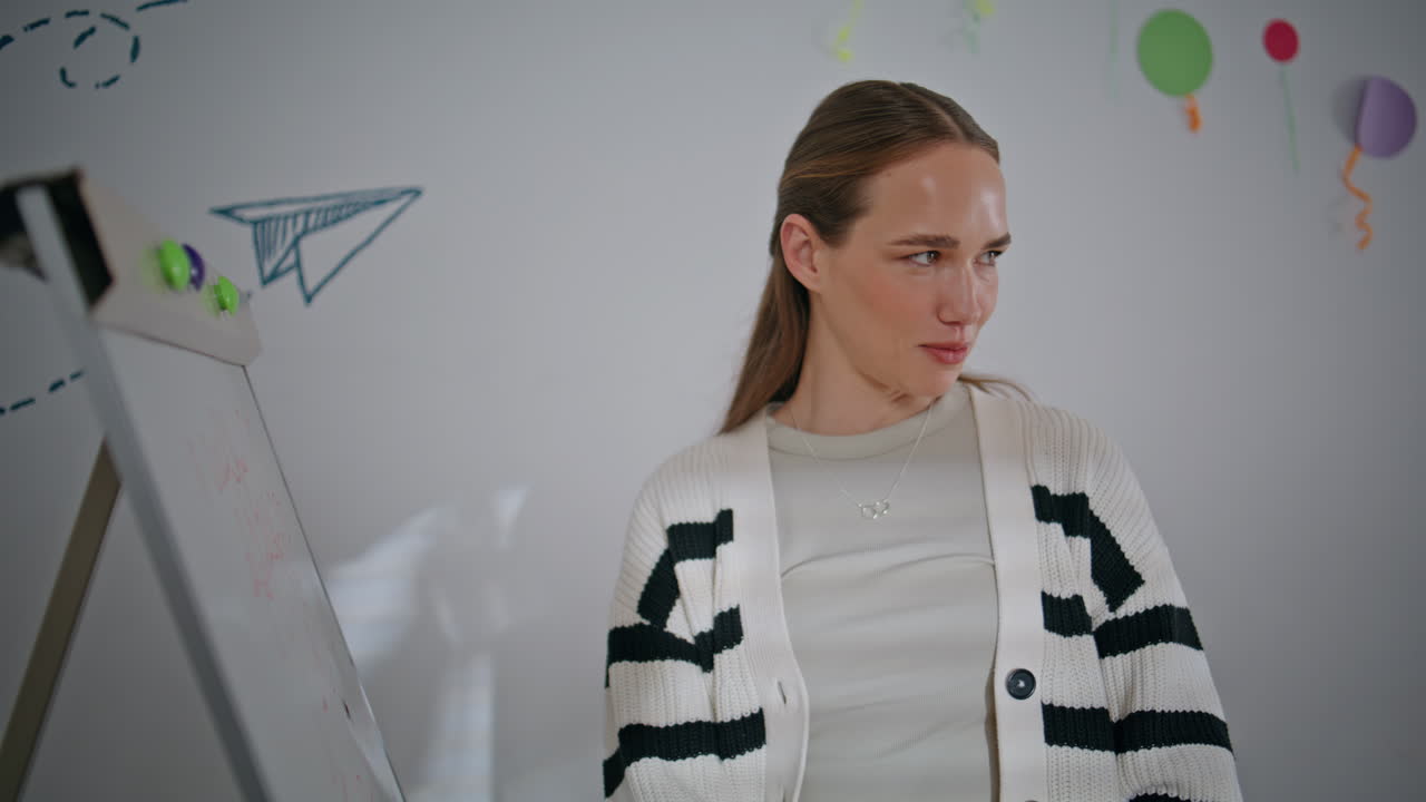 Happy schoolteacher explaining lecture material standing in classroom closeup