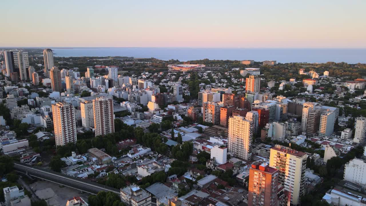 dolly volando sobre los edificios del barrio de belgrano al atardecer, río de la plata al fondo, buenos aires, argentina