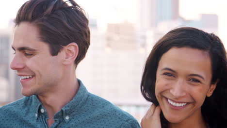 Portrait-Of-Friends-Gathered-On-Rooftop-Terrace-For-Party-With-City-Skyline-In-Background