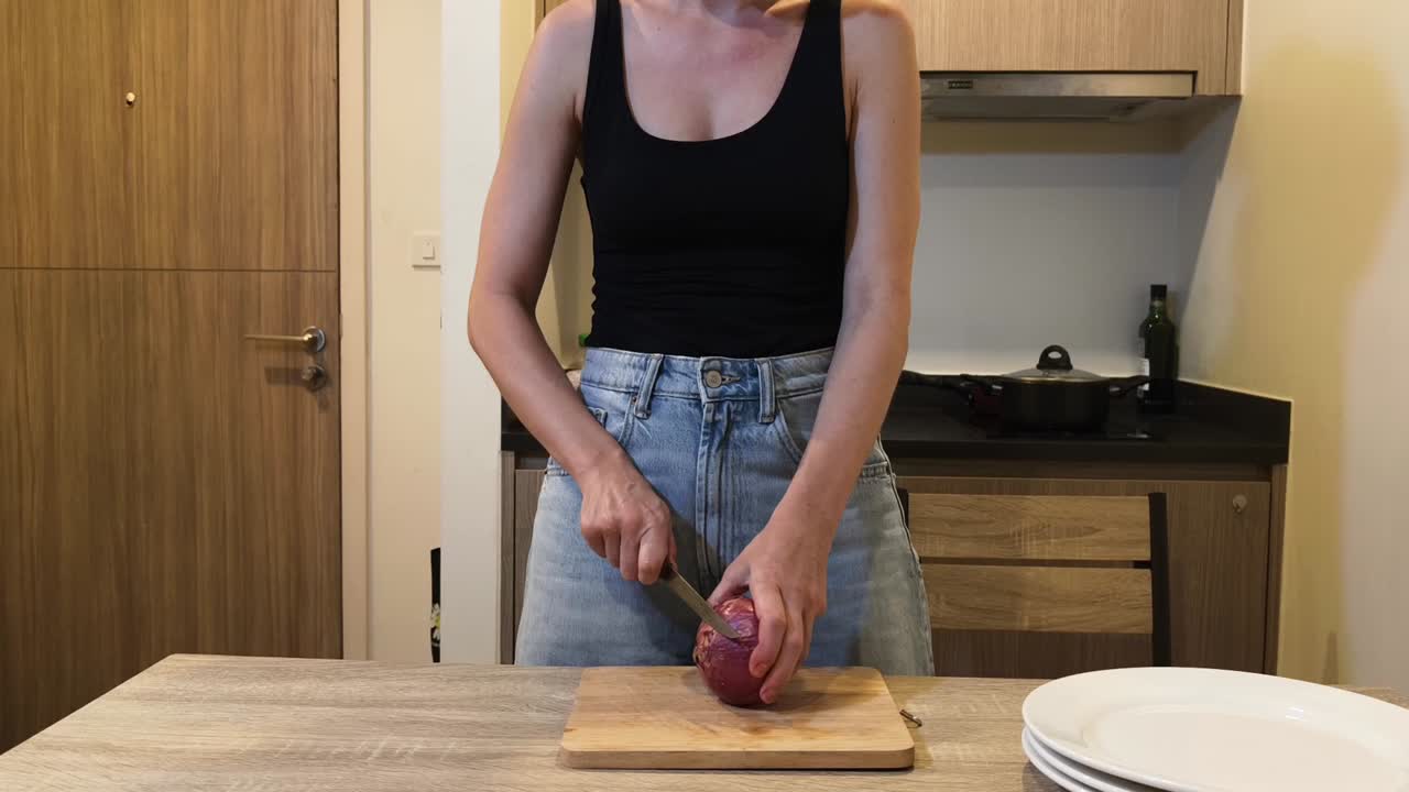 Woman peeling an onion in the kitchen