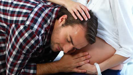 Smiling-man-listening-to-pregnant-womans-belly-in-ward