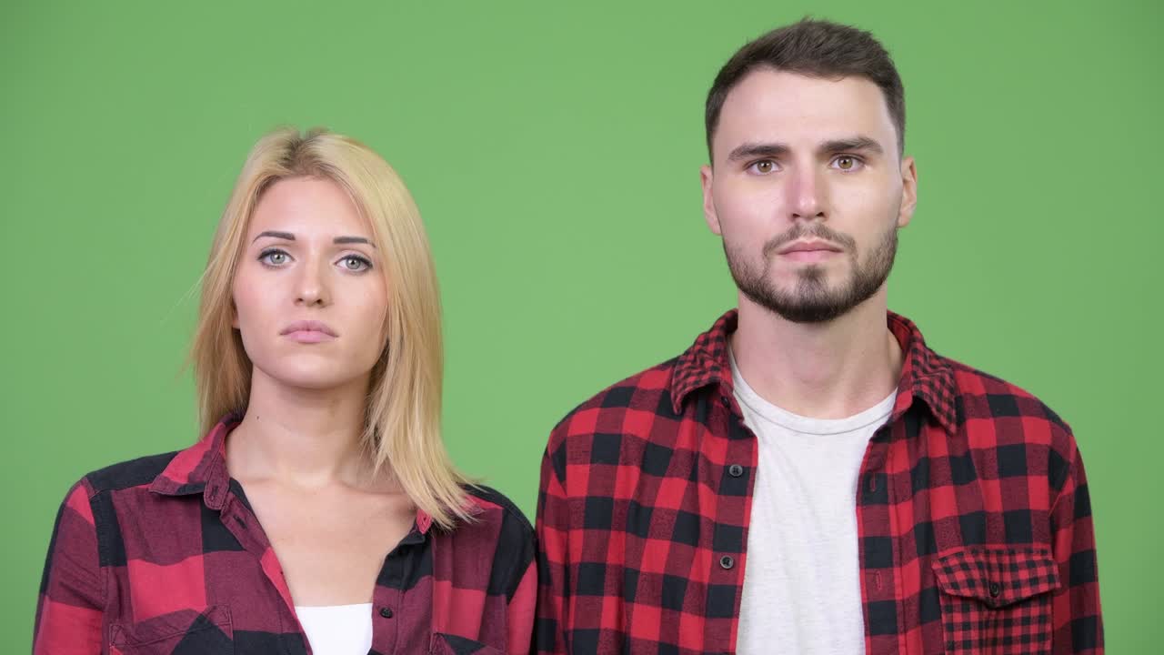 Young sad woman thinking together with young happy man