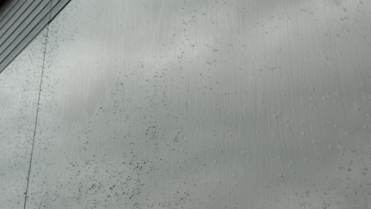 las gotas de lluvia rodan por el vidrio del espejo. las gotas en el vidrio están rodando por la ventana. la lluvia fuera de la ventana