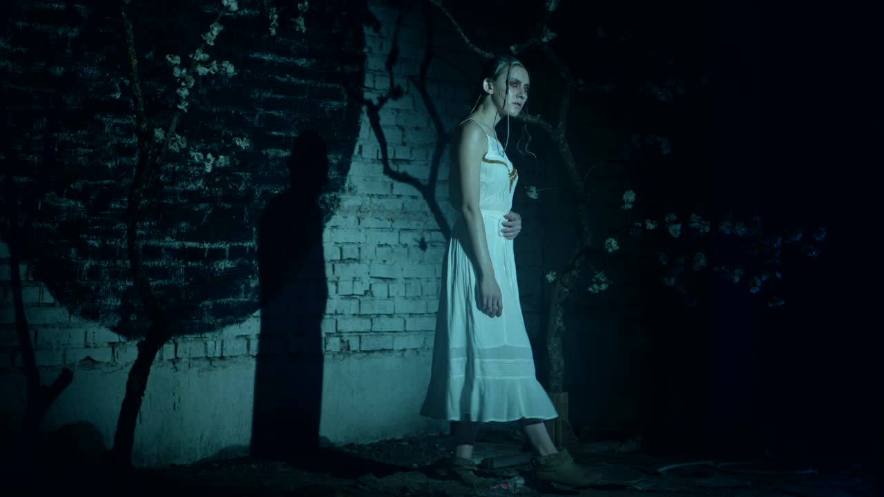 창의적인 패션 메이크업을 가진 기묘한 여성이 고 주변을 둘러보고 있습니다.