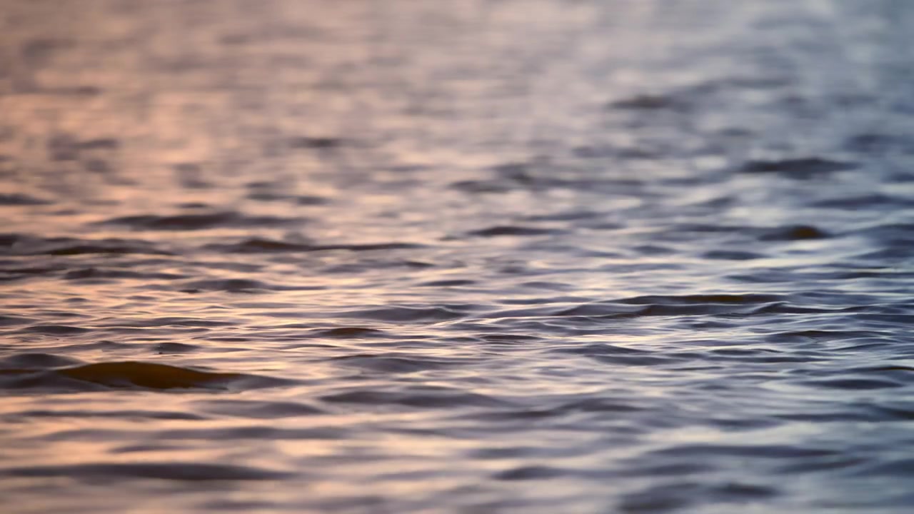 Close-up of Water Surface with Ripples and Colorful Reflections