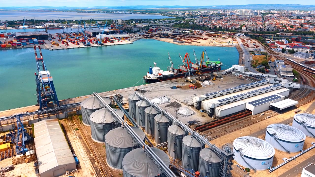 Nahaufnahme von schwerem Gerät beim Verladen eines Containers am Dock. Detaillierte Ansicht von automatisierten Hafenanlagen, die einen Metall-Seecontainer während des Frachtumschlags heben.