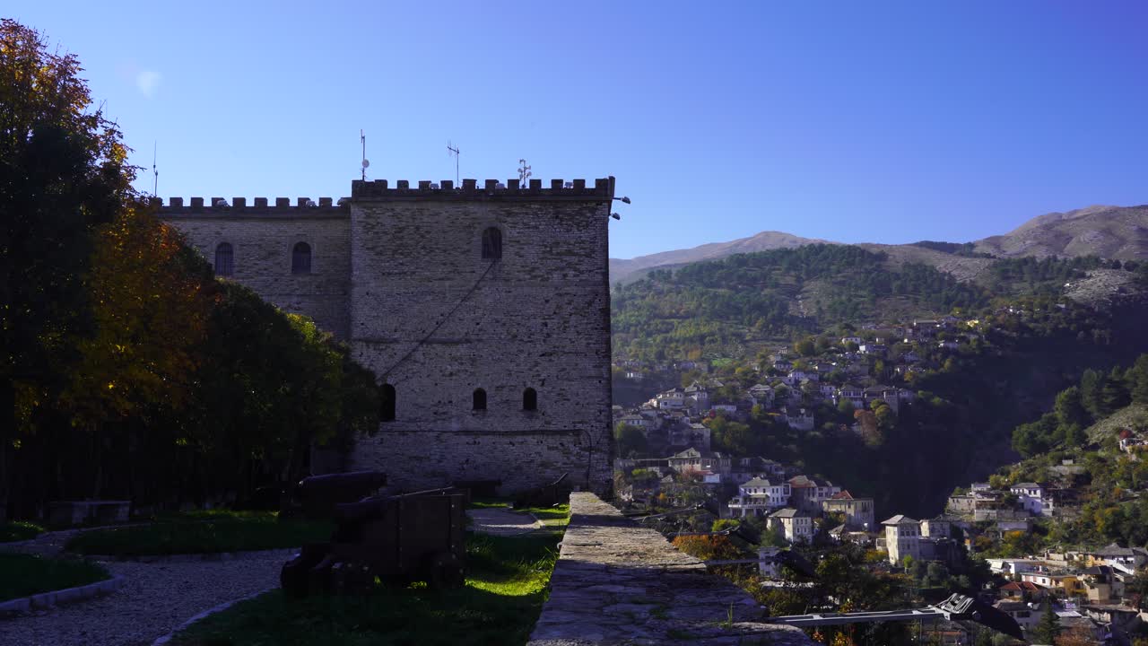 torre de fortaleza con paredes gruesas de piedra y fondo de casas tradicionales en gjirokaster