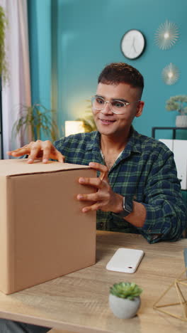 hombre feliz comprador desempaque caja de cartón entrega paquete compras en línea compra en la oficina de casa