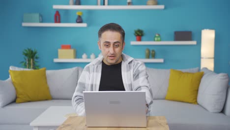 hombre mirando la computadora portátil con asombro.