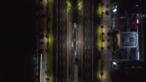 Top-down-overhead-aerial-view-of-empty-multi-lane-motorway-at-night-during-coronavirus-lockdown-in-modern-city-center