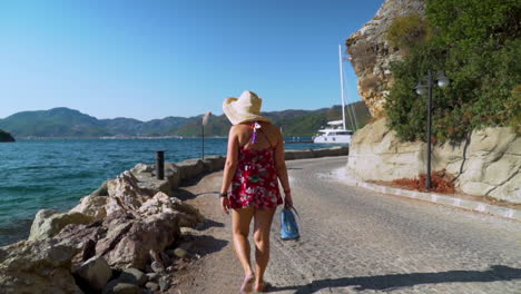 woman walking along a seaside path on a sunny summer day