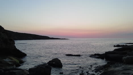 zoom in of sea waves breaking on rocks at sunset