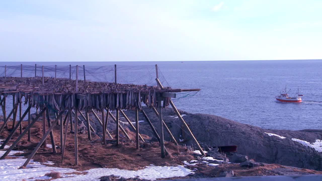 어선은 노르웨이 로포텐 섬의 어선 근처 북극의 피요르드를 통과합니다.