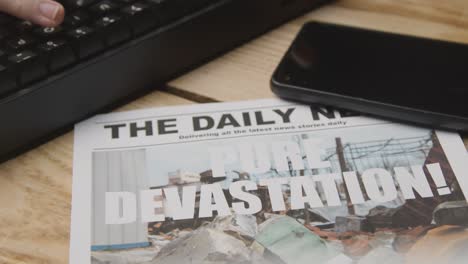 newspaper headline featuring devastation caused by earthquake disaster on desk next to computer keyboard and phone 2