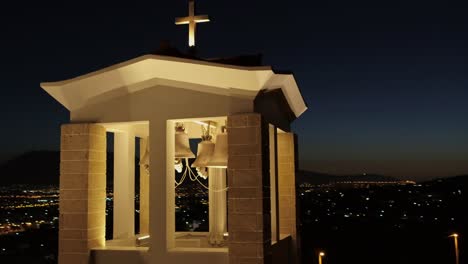 Aerial---Orthodox-church-bell-town-at-night-in-Pallini,-Athens,-Greece