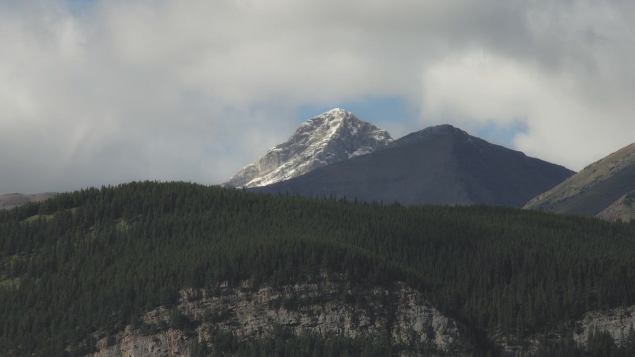 Kører forbi sneklædte tinder i Rocky Mountains om sommeren
