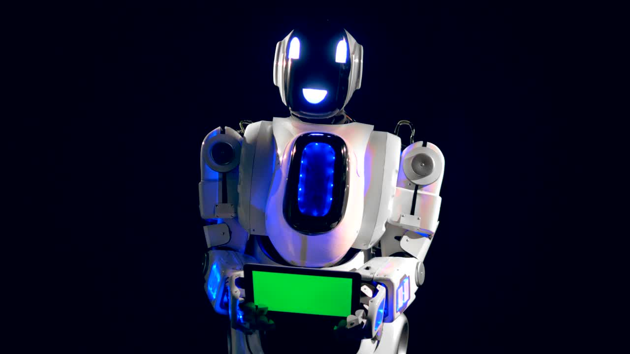 White robot turns to camera, holding a green screen board.