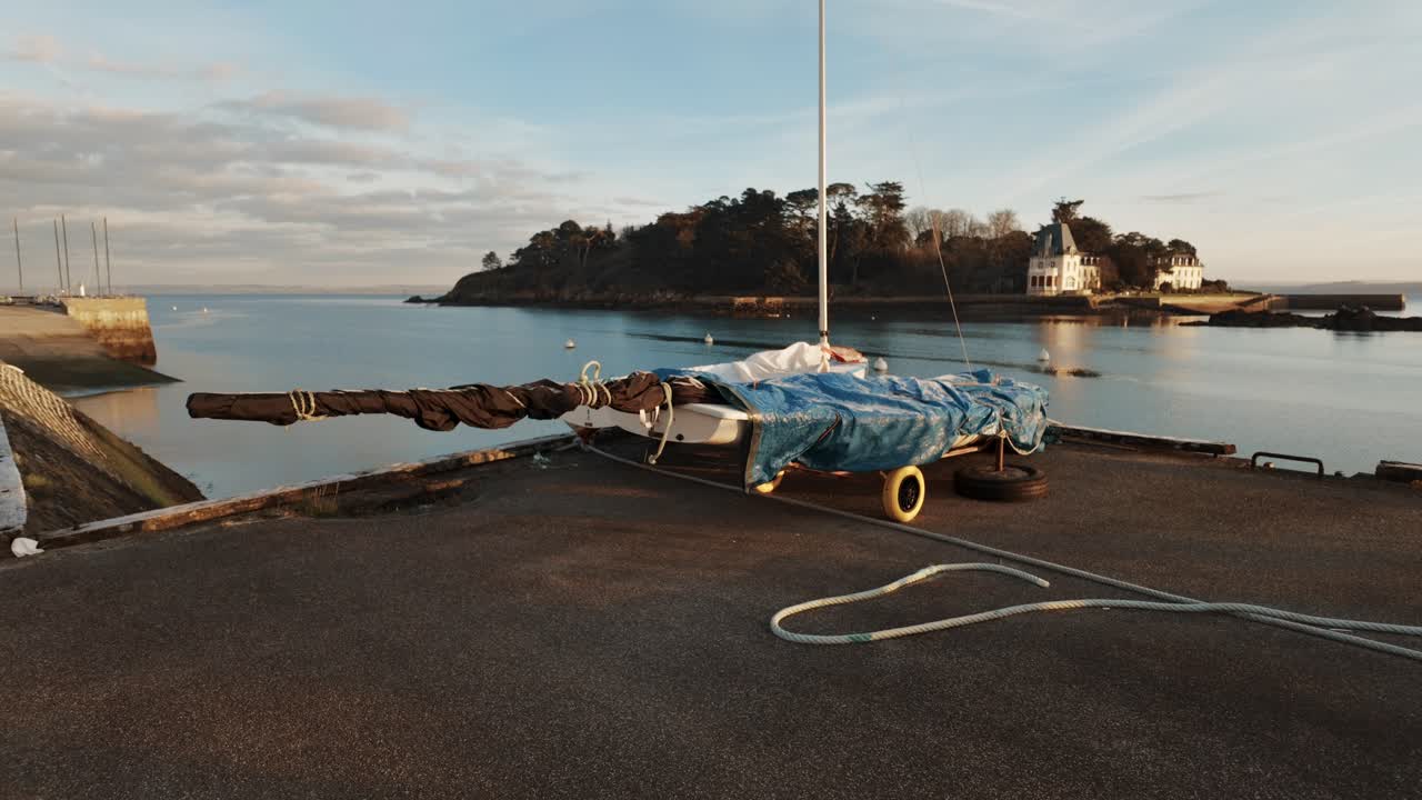 Wintered dinghy on harbour quayside at sunrise