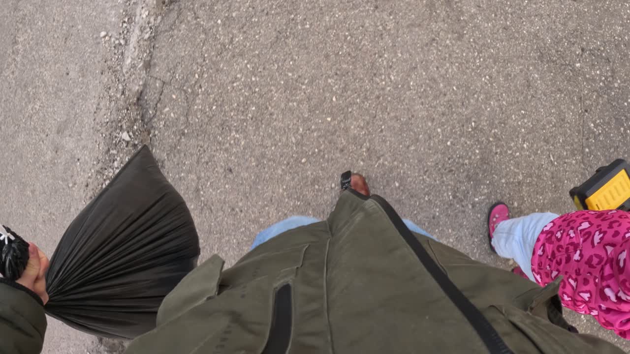 A parent and child walk together to take out the rubbish, capturing a simple and relatable family moment.