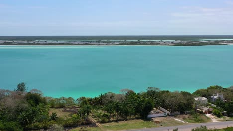 coastal-road-with-cars-at-Bacalar-Lagoon-in-Mexico-on-sunny-day,-aerial