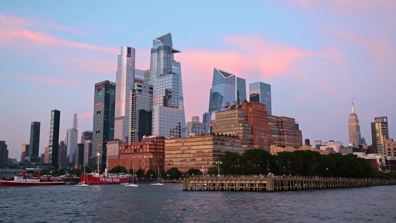 New York, USA, 21 June 2026 : Hudson Yards skyline view from the river in New York. Modern waterfront skyscrapers and pier during dusk under a pink and purple sunset sky.