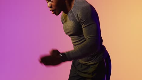 african american male runner with sportswear over pink lighting