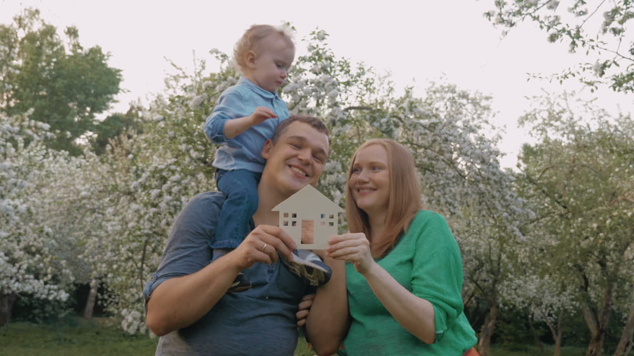 familia feliz con el modelo de casa como concepto de bienes raíces