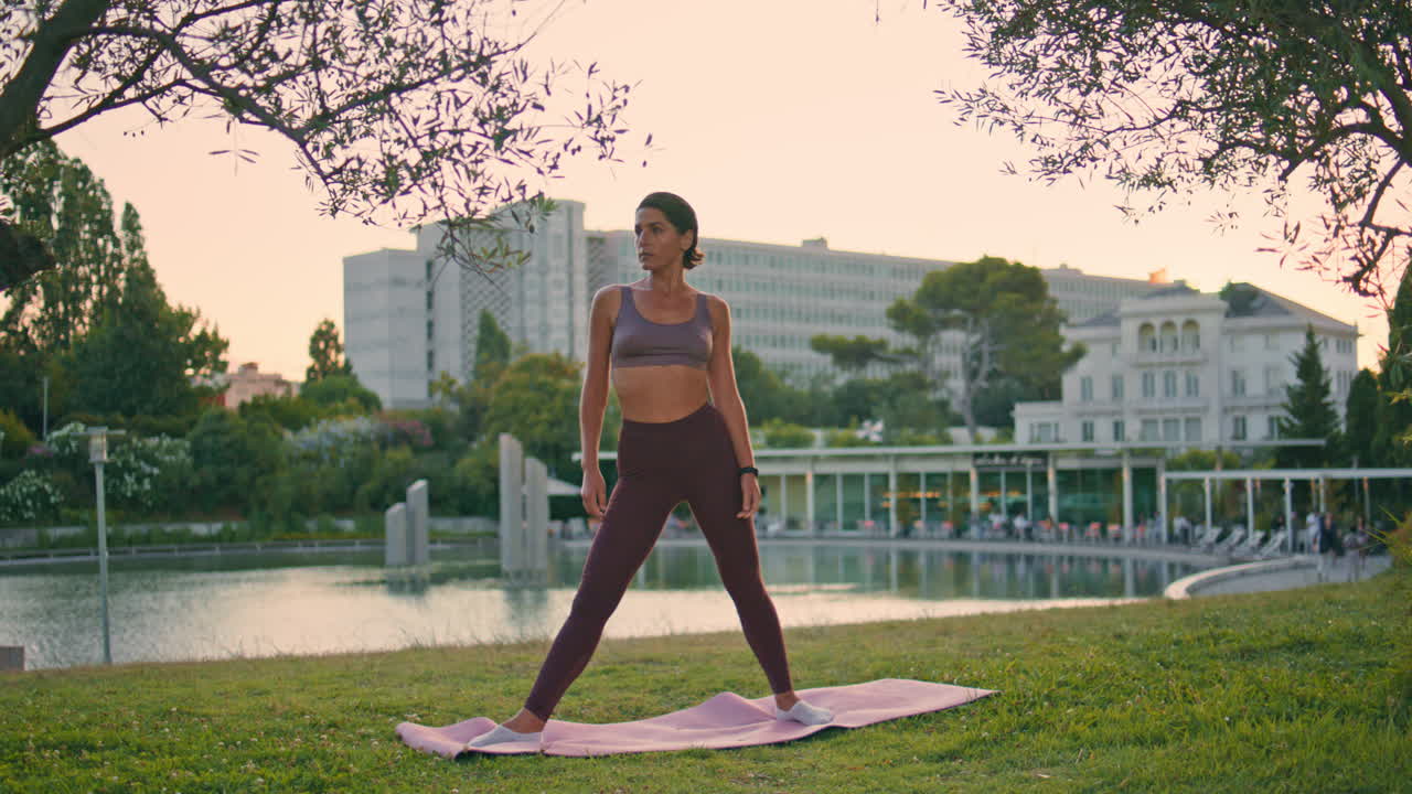 una deportista motivada hace ejercicio de pilates en el parque sunset. una mujer practica asanas.