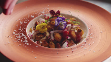 gourmet plated dish with edible flowers and sprinkled salt