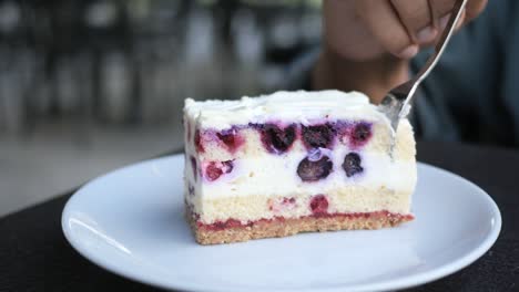 woman eating a slice of blueberry cake