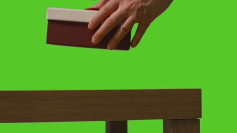 Close-Up-Of-Man-Picking-Up-Gift-Wrapped-Present-From-Table-Shot-Against-Green-Screen-1