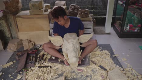 artisan proud of his detailed balinese barong wooden mask