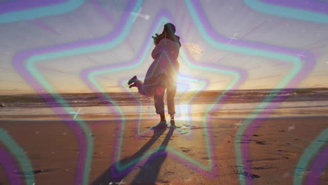 silhouetted couple embracing on beach with colorful star animation overlay
