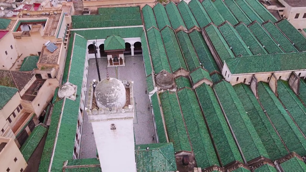 Vista aerea dall'alto con drone del minareto della Moschea Al Quaraouiyine e dei tetti con tegole verdi nella storica Medina di Fez, Marocco, ideale per progetti culturali.