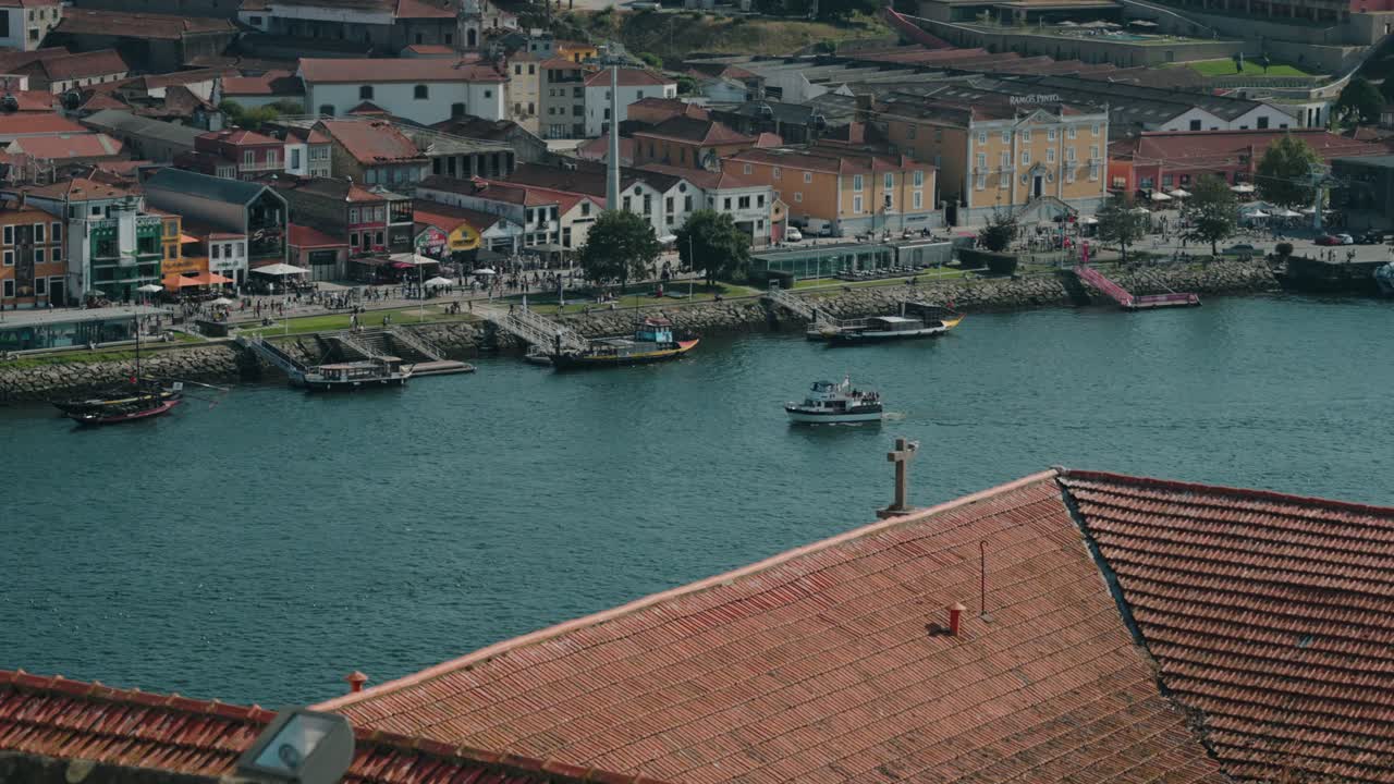 boats sailing on the Douro River with Ribeira waterfront buildings in Porto Portugal