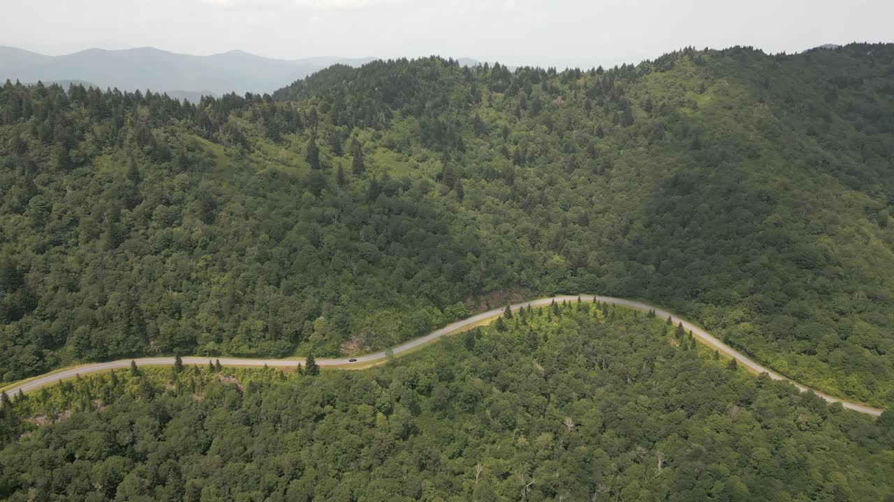 coche y moto en la vista aérea de la montaña humeante sinuosa carretera forestal