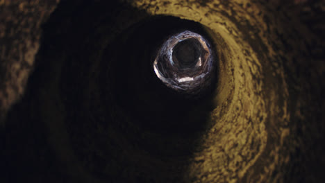 Beautiful-slow-motion-shot-of-the-hole-in-a-cavern-that-serves-as-a-subway-wine-cellar-in-Spain